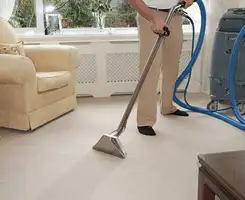 Carpet cleaning professional removing dirt and stains with a hot-water extraction tool in a home, Akron, OH.