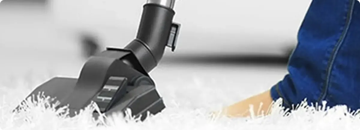 Close-up of a professional vacuuming a white carpet in Cuyahoga Falls.